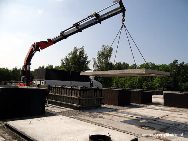 Załadunek szczelnego szamba betonowego do transportu  w Zbąszynku
